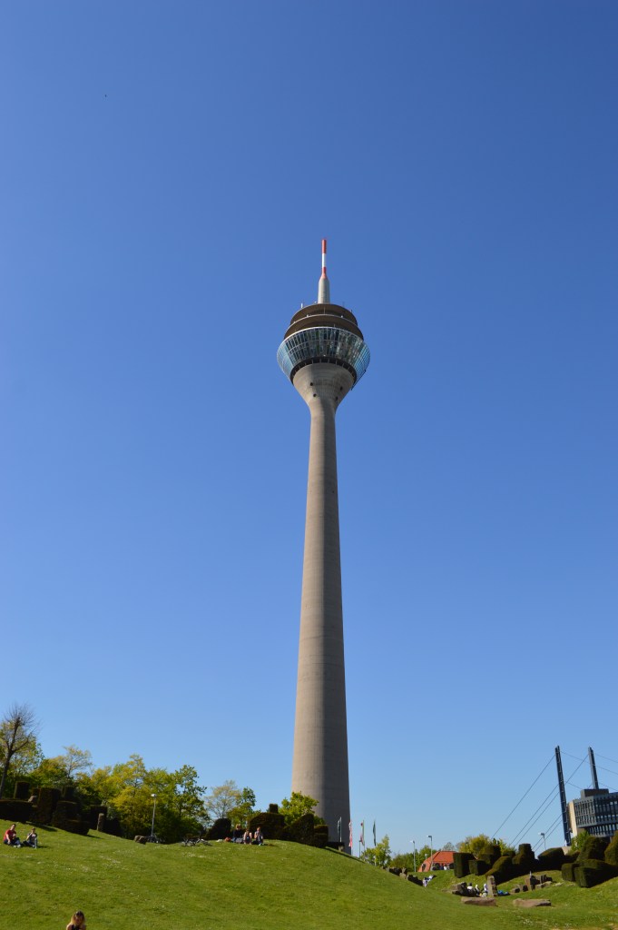 Rheinturm Düsseldorf – Tall telecommunications tower and city landmark against blue sky