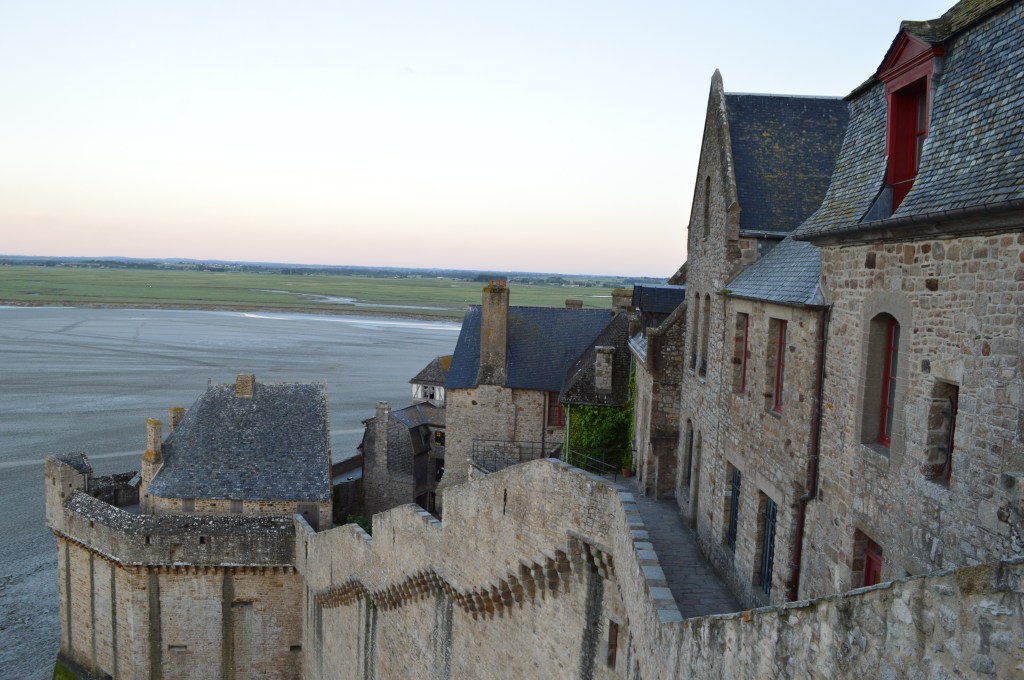 View from Mont Saint-Michel walls overlooking the tidal flats – Medieval architecture and vast landscape