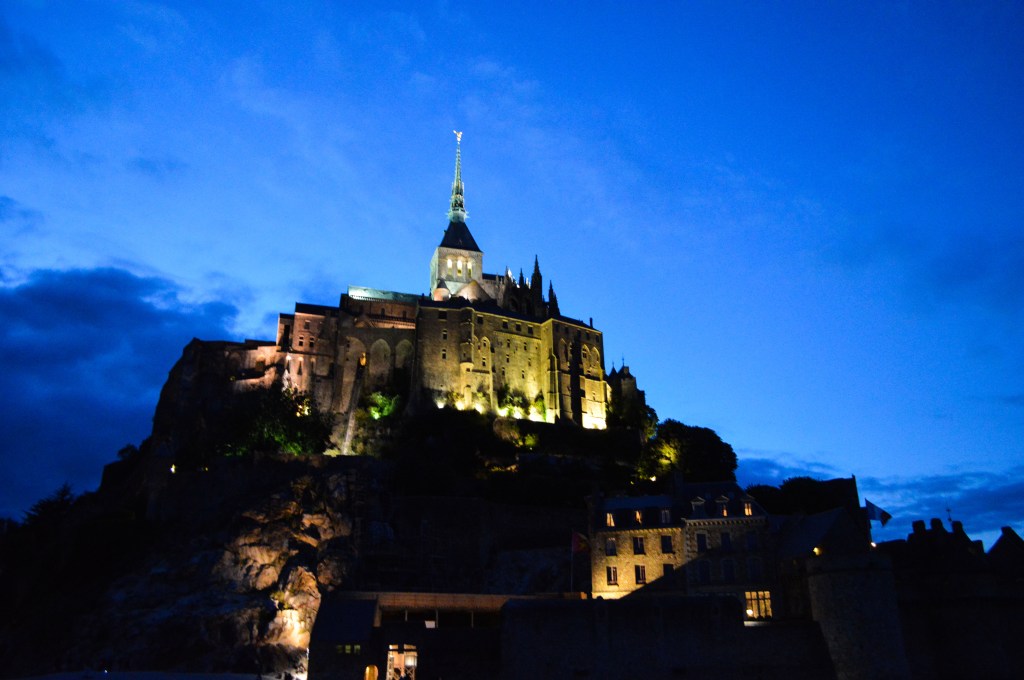 Mont Saint-Michel illuminated at night – Majestic glow of the abbey against a deep blue sky