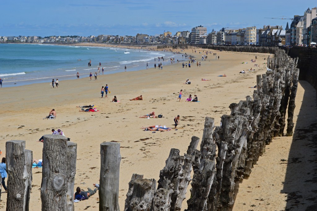 Crowded beach in Saint-Malo with historic town in the background – Popular summer destination in France