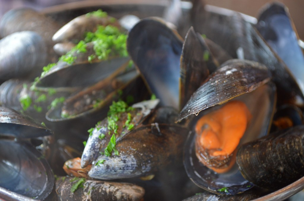 Moules marinières – Classic French mussel dish from the Normandy coast Freshly steamed mussels with parsley – Popular seafood delicacy in Normandy, France