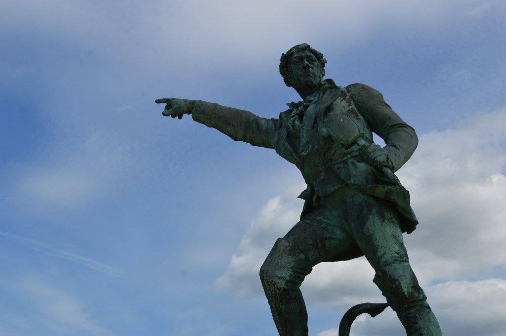 Statue of explorer Jacques Cartier in Saint-Malo – Pointing towards the sea under blue skies