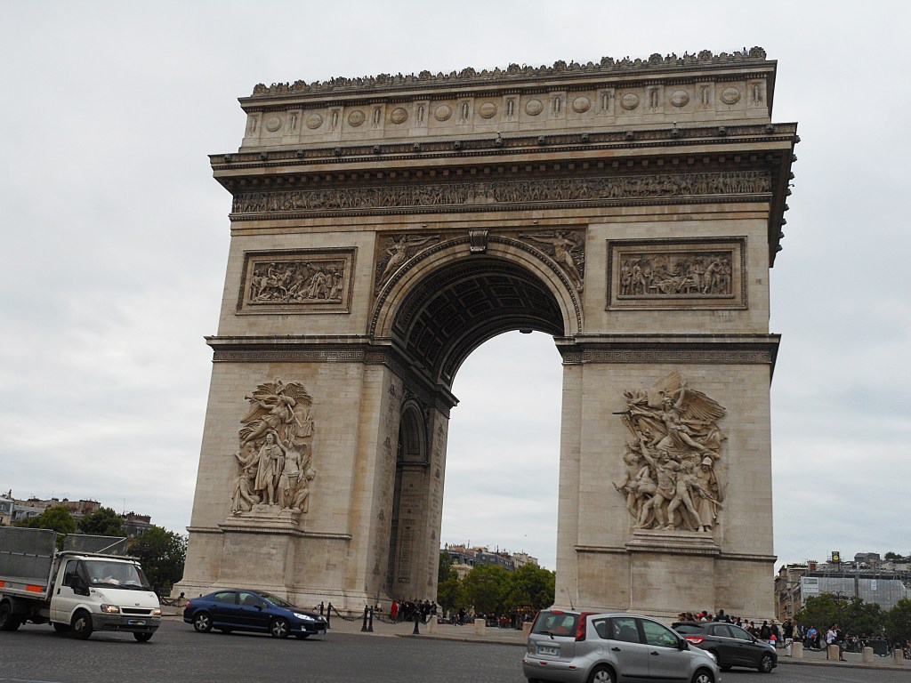 arc de triomphe with cars and cloudy sky in paris