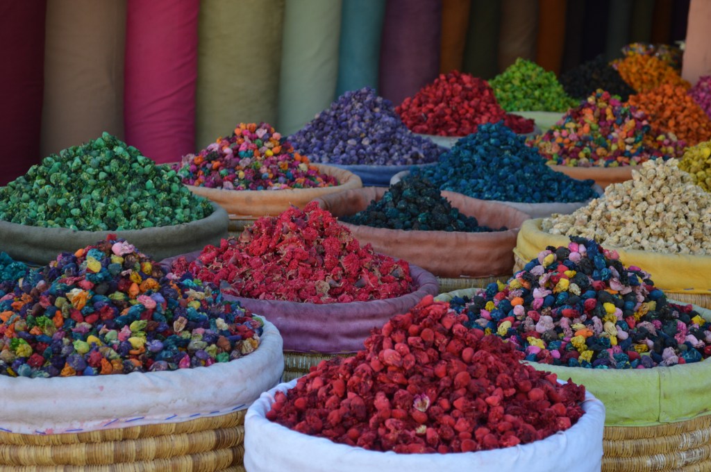 Vibrant spices and colorful fabrics in a Moroccan souk