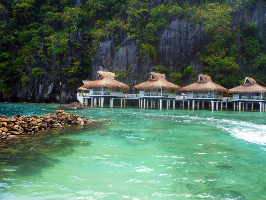 overwater cottages surrounded by turquoise water in el nido - El Nido stock photos