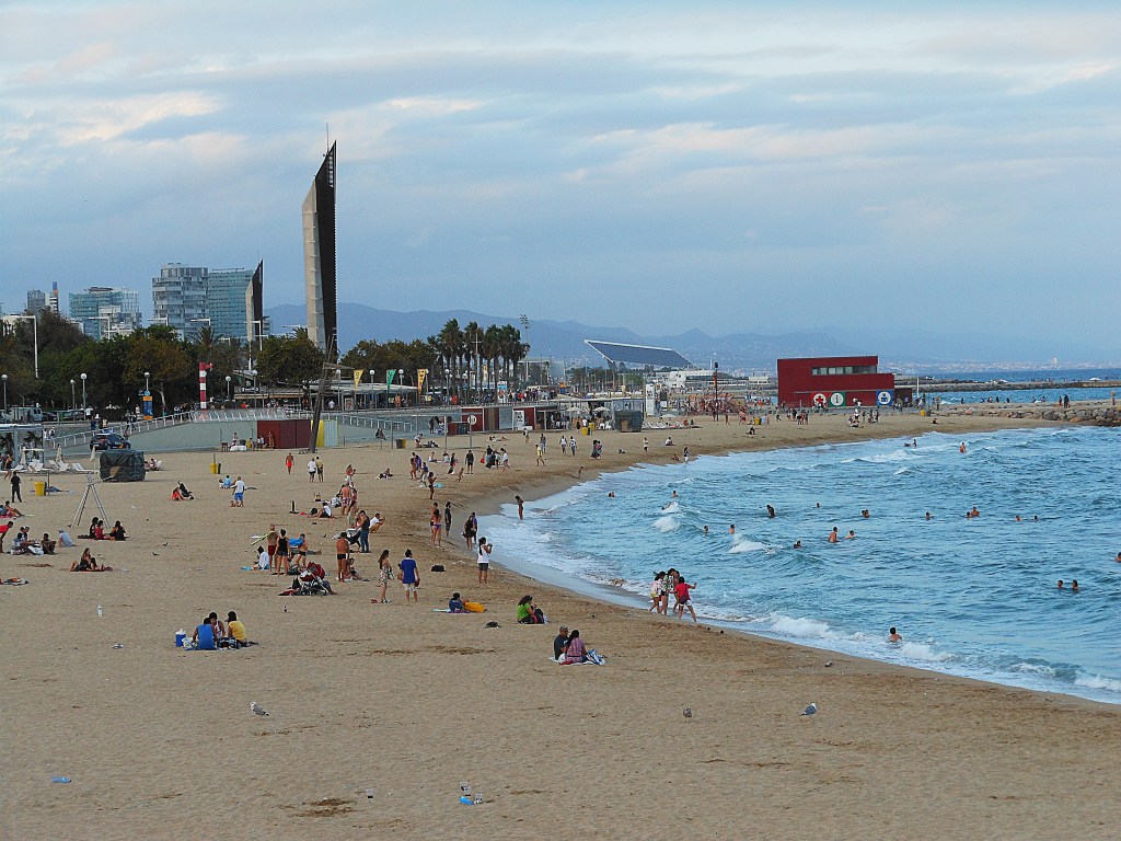 barceloneta beach with people and gentle waves – seaside life in barcelona