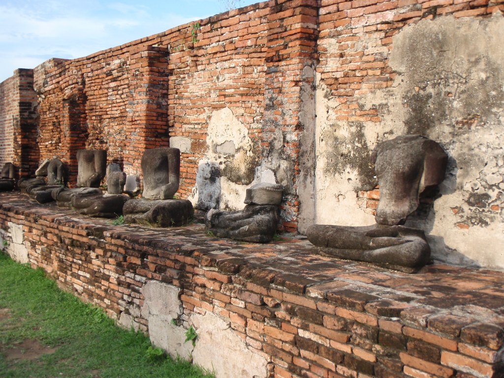 Broken Buddha statues and ancient ruins at Wat Mahathat, Ayutthaya, Thailand