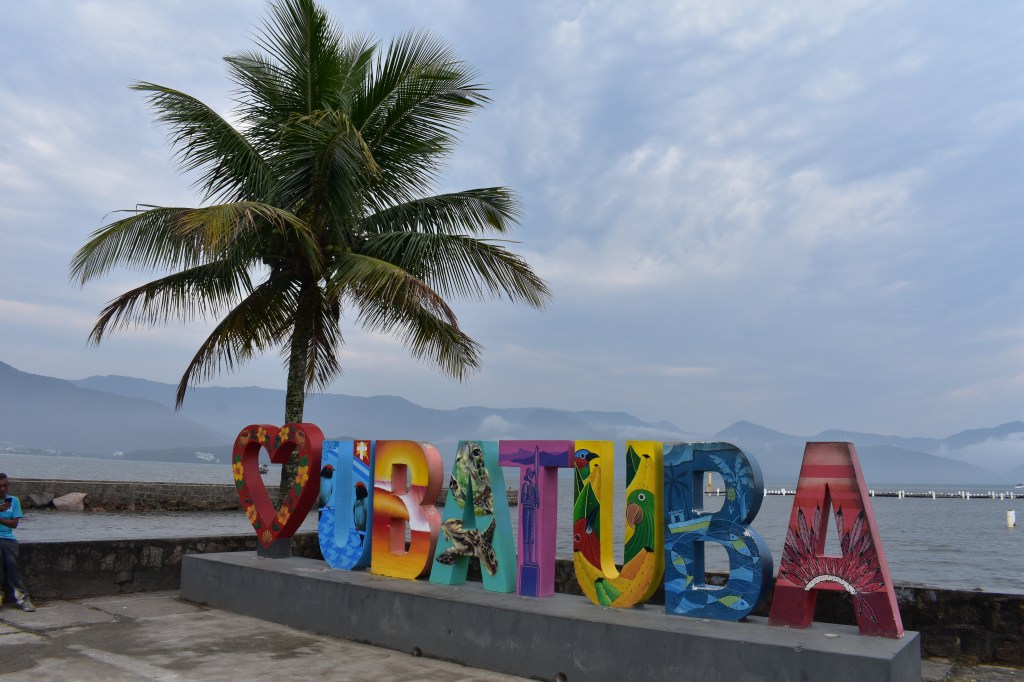 Colorful Ubatuba sign with palm tree and ocean in the background - Ubatuba stock photos