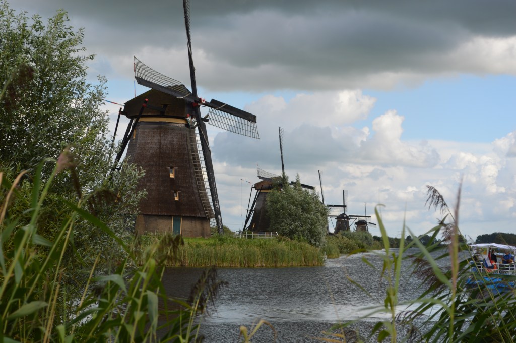 Multiple Dutch windmills along the canal under cloudy skies in Kinderdijk – Kinderdijk stock photos