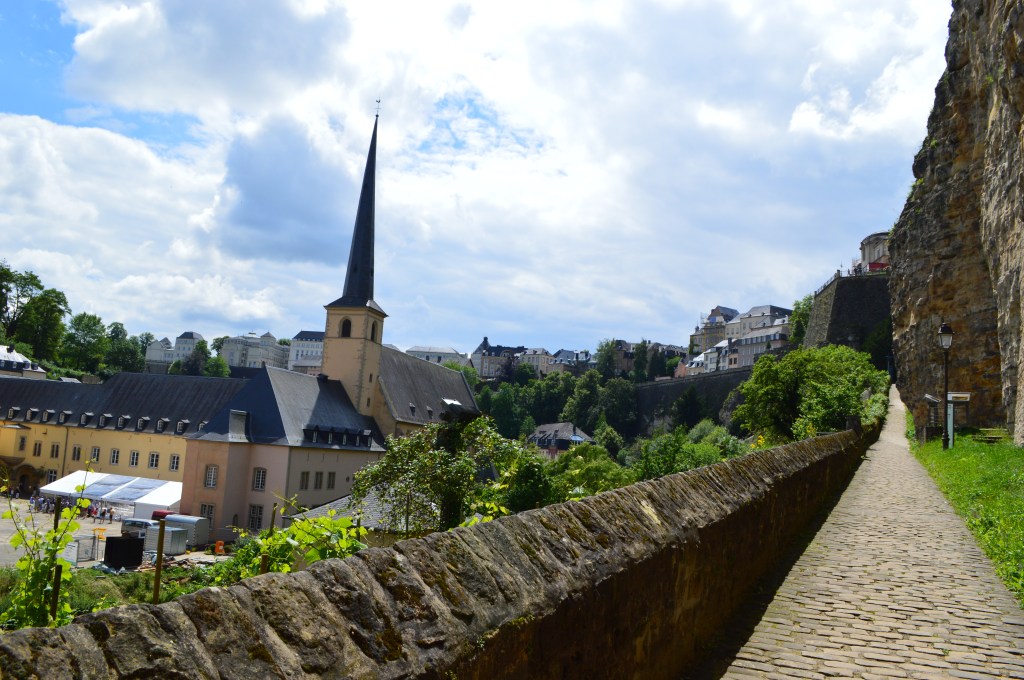 Church spire and scenic view of Luxembourg city with stone wall in foreground - Luxembourg stock photos